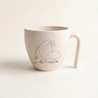 Skandinon PaussiCupissa Muumipeikko seisoo päällään valkoisella taustalla.